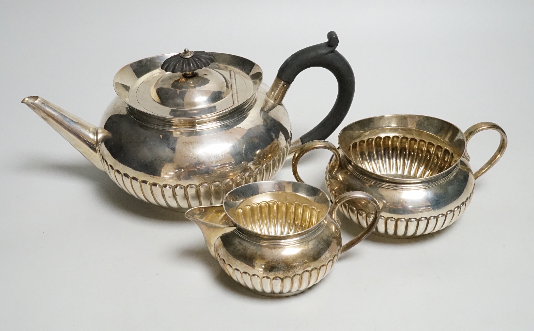 A late Victorian demi-fluted silver three piece tea set, by Hukin & Heath, 1893/4/5, gross weight 27.6oz.